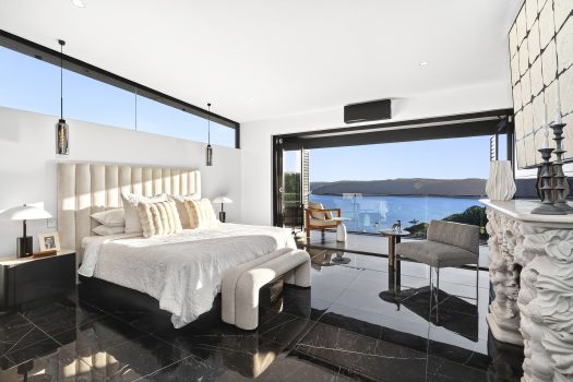 Luxurious bedroom with ocean view and modern decor.