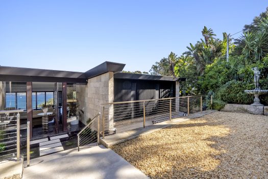 Modern house with ocean view and garden statue.