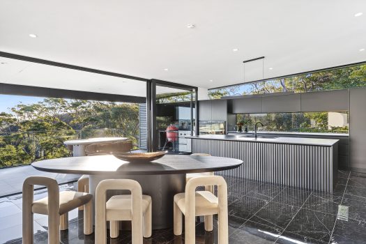 Modern kitchen with large windows and garden view.
