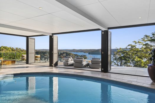 Luxury pool with ocean view balcony seating.